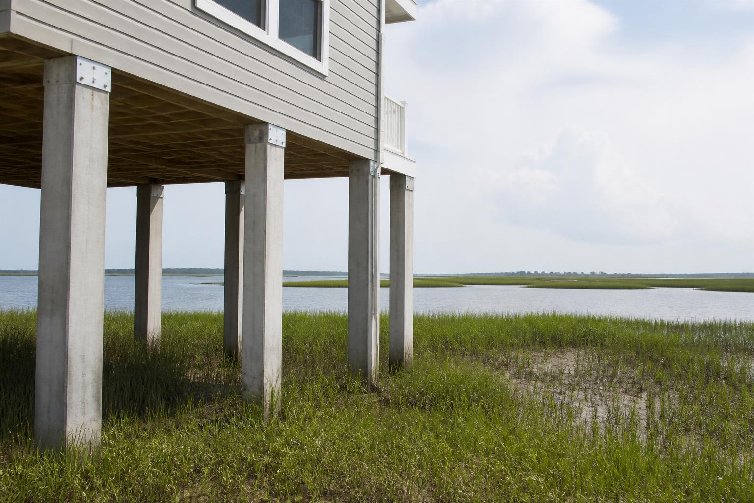 Elevated coastal framing on concrete piers above Lowcountry marsh grass